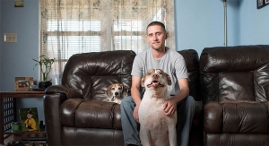 Young man sitting with his two dogs.