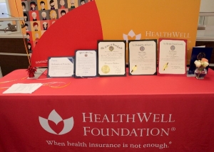 Five HealthWell Foundation awards on a table.